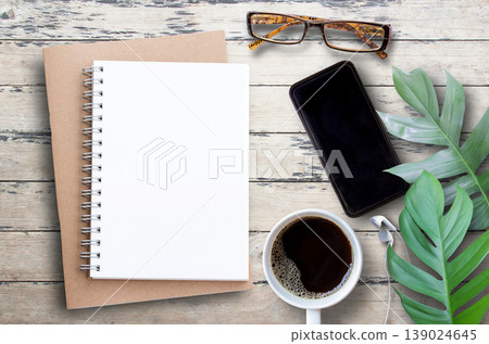 Top view with smartphone,glasses,cup of coffee and green leave on wood table background. Top view with smartphone,glasses,cup of coffee and green leave on wood table background. 139024645