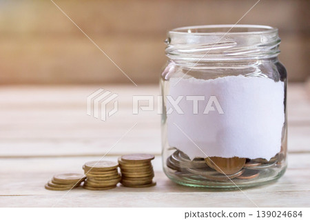 Money in the jar on wooden table with filter effect retro vintage style 139024684