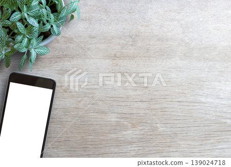 Smartphone white screen and fresh flower on wooden table background Smartphone white screen and fresh flower on wooden table background 139024718