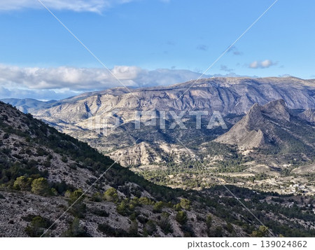 Brightly Illuminated Cliffs And Valleys, Sunlit Canyon With Rugged Cliffs And Distant Mountains 139024862