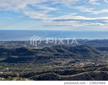 Vast And Peaceful Coastal Landscape Seen From High Ground With Gentle Clouds And Warm Sunlight 139024868