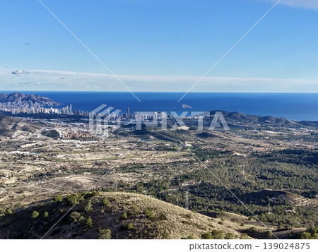 Bright Seaside View, Radiant Cityscape By Sea Featuring Distant Skyline And Natural Hill Formations Bright Seaside View, Radiant Cityscape By Sea Featuring Distant Skyline And Natural Hill Formations 139024875