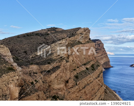 Majestic Steep Cliff Made Of Sandstones Overlooking Deep Blue Sea With Visible Geological Formations Majestic Steep Cliff Made Of Sandstones Overlooking Deep Blue Sea With Visible Geological Formations 139024921