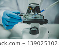 Close up scientist using pipette on microscope slide in laboratory experiment for biology chemistry and medical study 139025102
