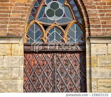 Decorated Church Entrance. Beautifully Adorned Wooden Church Door Featuring Stained Glass And Iron Fixtures 139025133