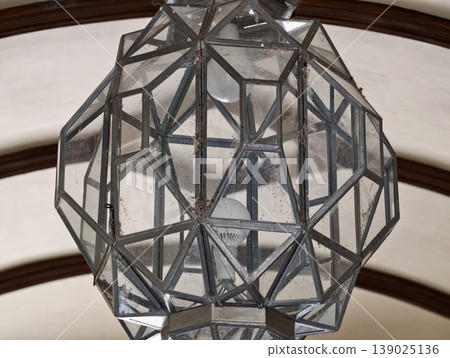 Decorative Chandelier Made Of Geometric Glass Panels And Metallic Accents Hanging From High Vaulted Ceilings 139025136