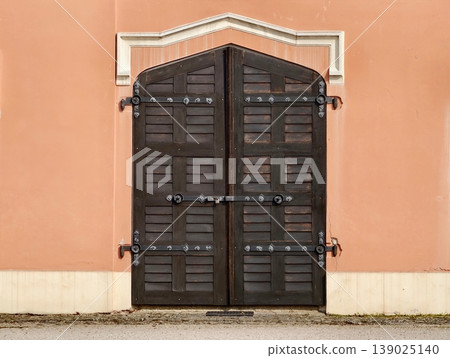 Ancient Doors With Detailed Hardware. Decorative Wooden Doors With Iron Fittings And Textured Surface 139025140