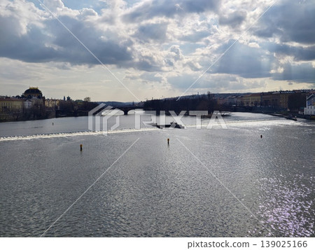 Sunshine Reflecting On Tranquil River With Dramatic Cloudy Background And Distant Bridge Crossing Sunshine Reflecting On Tranquil River With Dramatic Cloudy Background And Distant Bridge Crossing 139025166