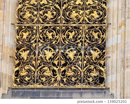 Ornamental Iron Lattice Featuring Intricate Leaf Designs And Luminous Gold Finish On Stone Framework 139025201