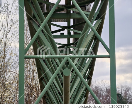 Complex Lattice Framework With Green Steel Braces Against Cloudy Sky Background For Visual Interest Complex Lattice Framework With Green Steel Braces Against Cloudy Sky Background For Visual Interest 139025543