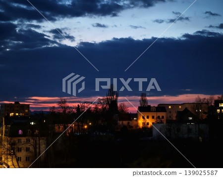 Dramatic Sunset Casting Shadows Over City Roofs Beneath Colorful Clouds And Warm Illuminations Dramatic Sunset Casting Shadows Over City Roofs Beneath Colorful Clouds And Warm Illuminations 139025587