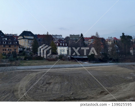 Tranquil Waterfront Town During Twilight Hours. Calm Landscape With Empty Sands And Muted Building Facades Tranquil Waterfront Town During Twilight Hours. Calm Landscape With Empty Sands And Muted Building Facades 139025595