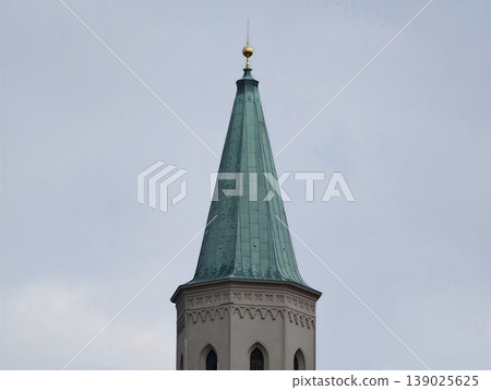 Majestic Copper Spire Tower Rising Over Cityscape With Detailed Masonry And Moody Lighting Conditions 139025625