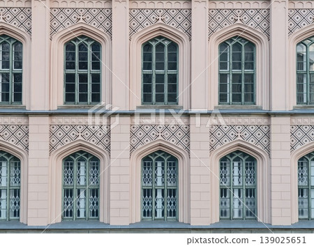 Soft Pink Building With Arches. Gentle Pastel Hued Exterior Featuring Arches And Decorative Detailing 139025651
