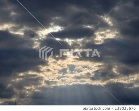 Twilight Clouds With Shining Rays. Nightfall Over Storm Clouds With Shimmering Sunbeams Breaking Through Twilight Clouds With Shining Rays. Nightfall Over Storm Clouds With Shimmering Sunbeams Breaking Through 139025676