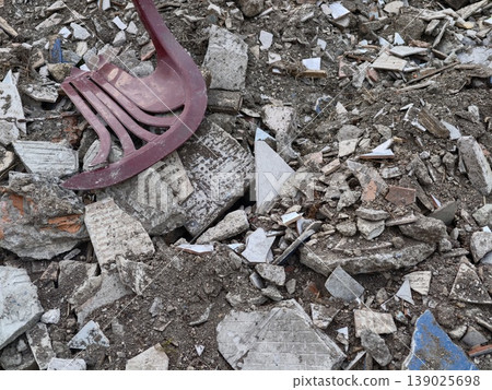 Neglected Plastic Chair Positioned Within Cluttered Landscape Of Debris And Weathered Materials Neglected Plastic Chair Positioned Within Cluttered Landscape Of Debris And Weathered Materials 139025698