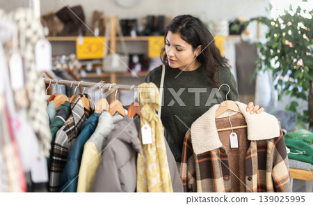 Latina chooses outerwear in the store 139025995