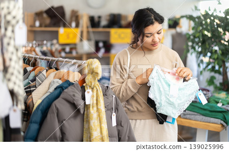 Latina woman choosing lingerie in a clothing store Latina woman choosing lingerie in a clothing store 139025996