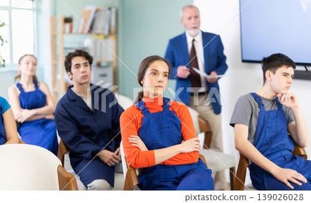 Young students in blue overalls attending technical seminar 139026028