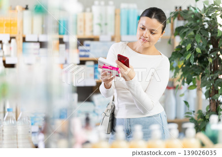 Middle-aged woman customer scanning QR-code on paracetamol box Middle-aged woman customer scanning QR-code on paracetamol box 139026035