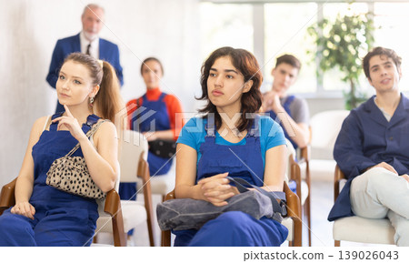 Mature male lecturer in background of classroom, address to young employee listeners. Mature male lecturer in background of classroom, address to young employee listeners. 139026043