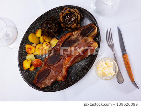 Spanish cuisine, churrasco de ternera, served with artichokes 139026089