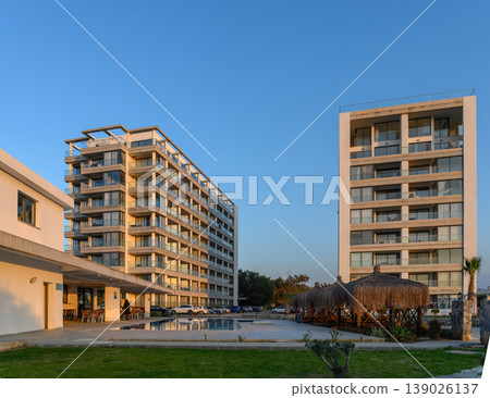 Modern architecture harmonizes with nature at a serene residential complex during golden hour Modern architecture harmonizes with nature at a serene residential complex during golden hour 139026137