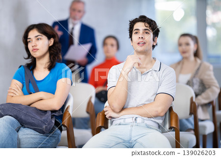 Mature male lecturer in background of classroom, address to young students. Mature male lecturer in background of classroom, address to young students. 139026203