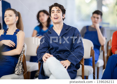 Mature male lecturer in background of classroom, address to young employee listeners. Mature male lecturer in background of classroom, address to young employee listeners. 139026211