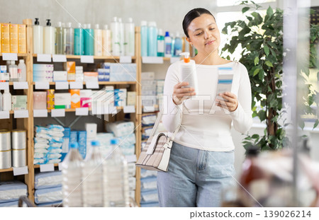 Middle-aged woman choosing cream in drugstore Middle-aged woman choosing cream in drugstore 139026214