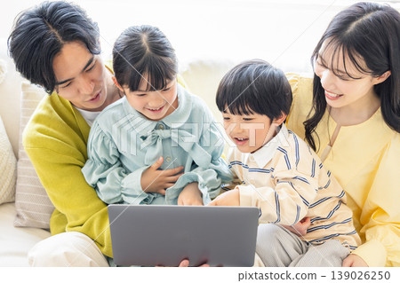 Family looking at a computer in the living room 139026250