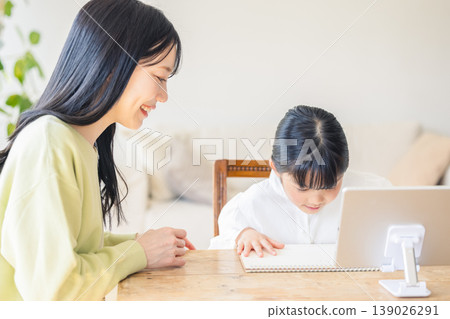 一個女孩和她的母親在客廳學習 139026291