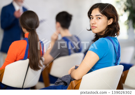 Filipina woman sits at a construction course against the background of other students Filipina woman sits at a construction course against the background of other students 139026302