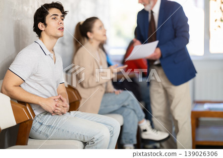 Guy sits in line to sign up in school driving courses and take exams Guy sits in line to sign up in school driving courses and take exams 139026306