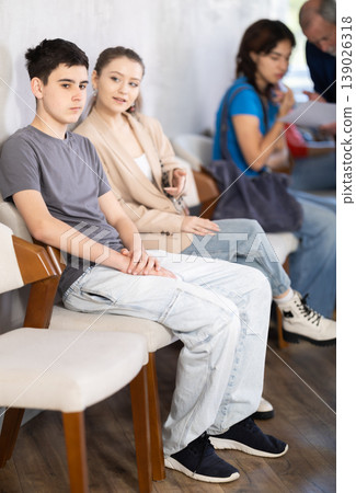 Queue of applicants in reception room, senior male manager talking to office-seeker in background. 139026318