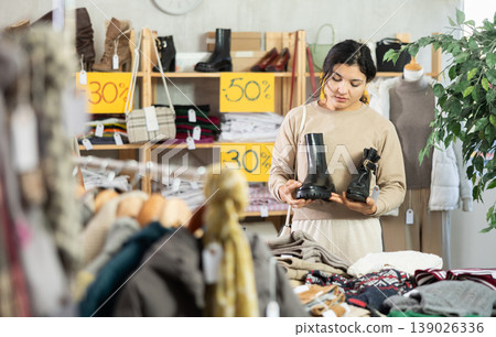 Latina chooses shoes in a clothing store Latina chooses shoes in a clothing store 139026336