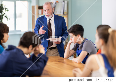 During round table conference, senior man mentor shouts at worker students 139026348