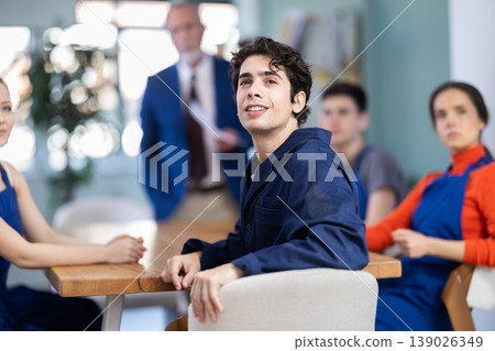 Mature male speaker address to young workers, man delivers lecture. Mature male speaker address to young workers, man delivers lecture. 139026349
