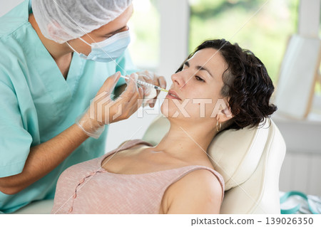 Middle-aged woman having face care by means of injection in aesthetic clinic 139026350