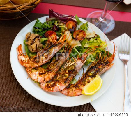 Seafood dish. Tasty grilled shrimp served with vegetables and lemon Seafood dish. Tasty grilled shrimp served with vegetables and lemon 139026393