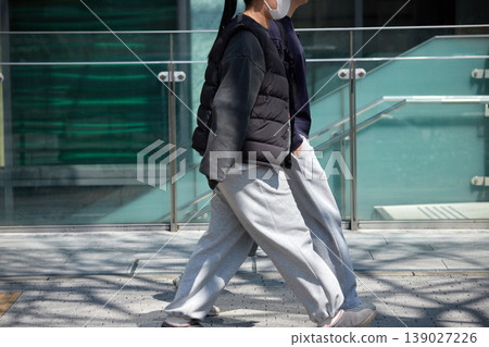白天,一對年輕男女走在熙熙攘攘的城市街道上。 白天,一對年輕男女走在熙熙攘攘的城市街道上。 139027226