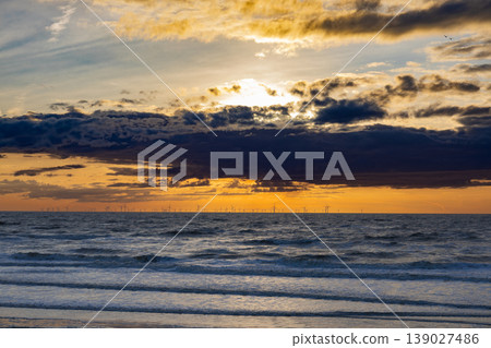 Ocean sunset with offshore wind turbines on horizon renewable energy and sustainable future concept Ocean sunset with offshore wind turbines on horizon renewable energy and sustainable future concept 139027486
