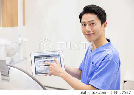 Dentist explaining while showing a tablet 139027537