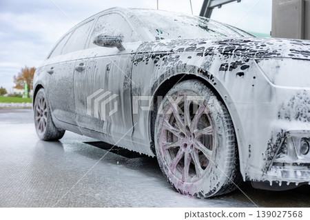 Car covered with foam during washing process at self service cleaning station Car covered with foam during washing process at self service cleaning station 139027568