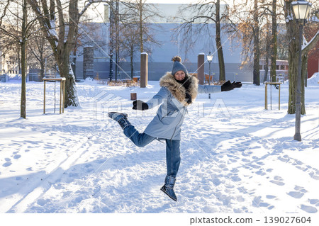 Happy woman enjoying winter snow in park playful outdoor lifestyle seasonal joy concept Happy woman enjoying winter snow in park playful outdoor lifestyle seasonal joy concept 139027604