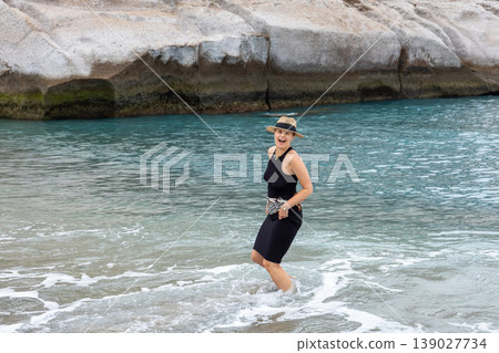Happy Woman Enjoying Ocean Waves On Sandy Beach During Summer Vacation Happy Woman Enjoying Ocean Waves On Sandy Beach During Summer Vacation 139027734