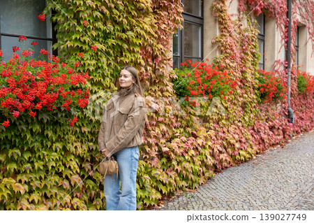 Stylish Woman Walking Along Colorful Ivy Covered Building Autumn City Street Stylish Woman Walking Along Colorful Ivy Covered Building Autumn City Street 139027749