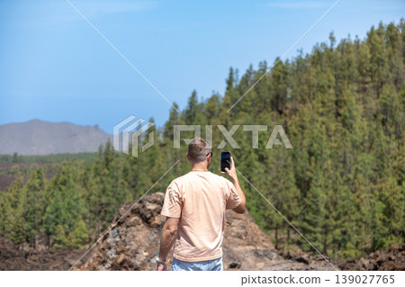 Man Taking Photo with Smartphone on Mountain Viewpoint Travel Adventure Scene 139027765