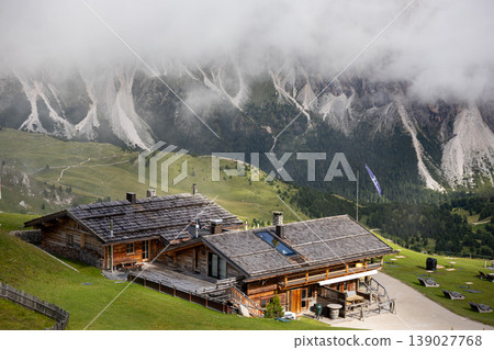 Cozy wooden mountain chalet in the Dolomites, Italy, surrounded by alpine landscape in summer. Cozy wooden mountain chalet in the Dolomites, Italy, surrounded by alpine landscape in summer. 139027768