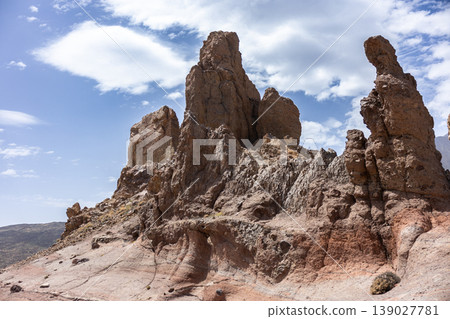 Rock Formation In Arid Volcanic Desert Landscape Under Bright Cloudy Sky Rock Formation In Arid Volcanic Desert Landscape Under Bright Cloudy Sky 139027781